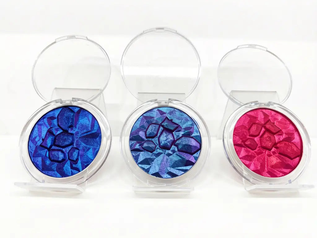 metallic eyeshadow pans with blue cyan and red reflective pigment effect